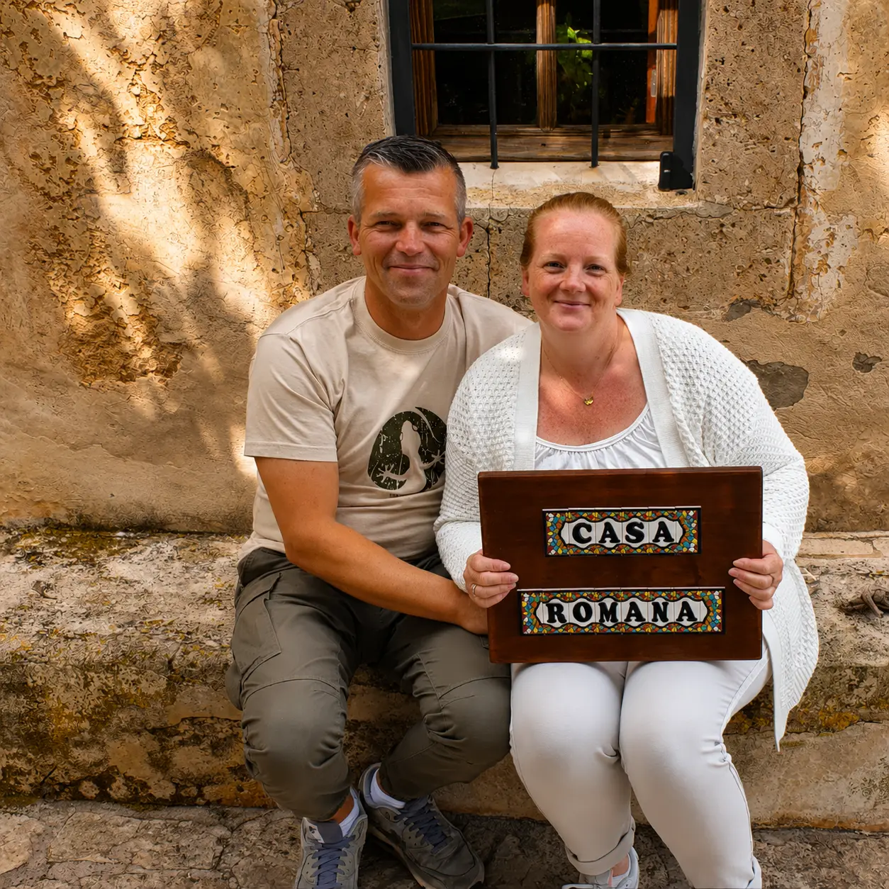 A couple sitting together with the Casa Romana sign